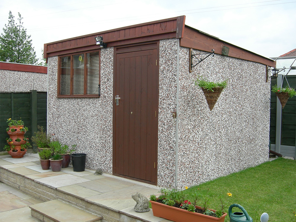 Concrete workshop in a garden with a wooden door